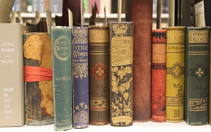 spines of different editions of Little Women by Louisa May Alcott