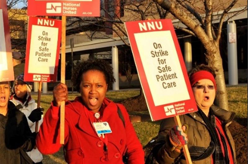 nurses holding picket signs